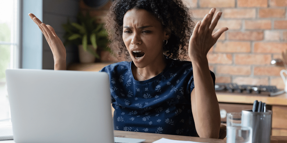 This image shows a woman that is frustrated in angry while looking at her laptop