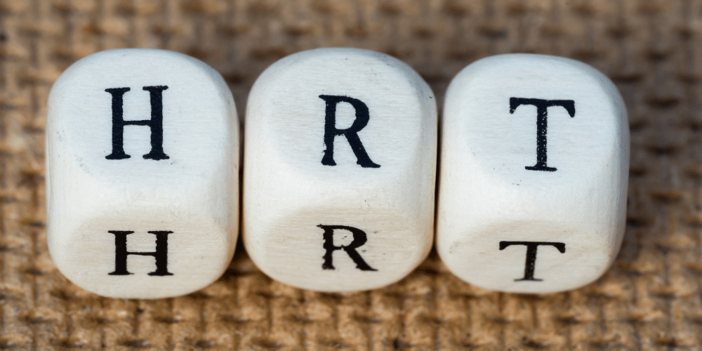 The photo is of a group of white and black dice arranged in a pattern. The dice have the letters H, R, and T on them. It is a number-related indoor image.