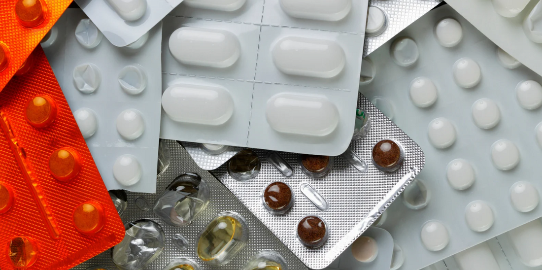 Various types of pills and capsules in blister packs.