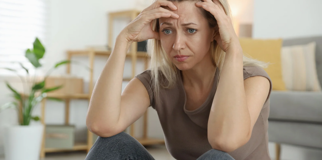 Woman sits distressed.