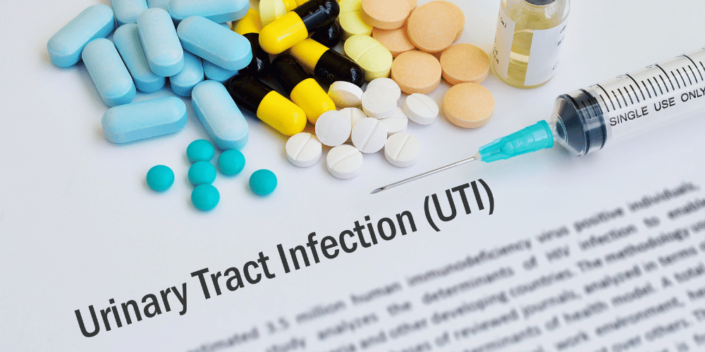 The image is a close-up of pills arranged on a piece of paper. The paper has text mentioning "Urinary Tract Infection (UTI)" 