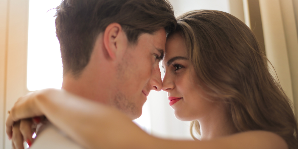 The image shows an intimate moment between a man and a woman as they look at each other.