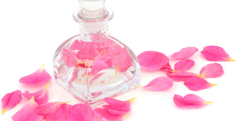 The image is a glass bottle containing pink liquid, possibly perfume. It is tagged as a bottle, perfume, toiletry, and flower.