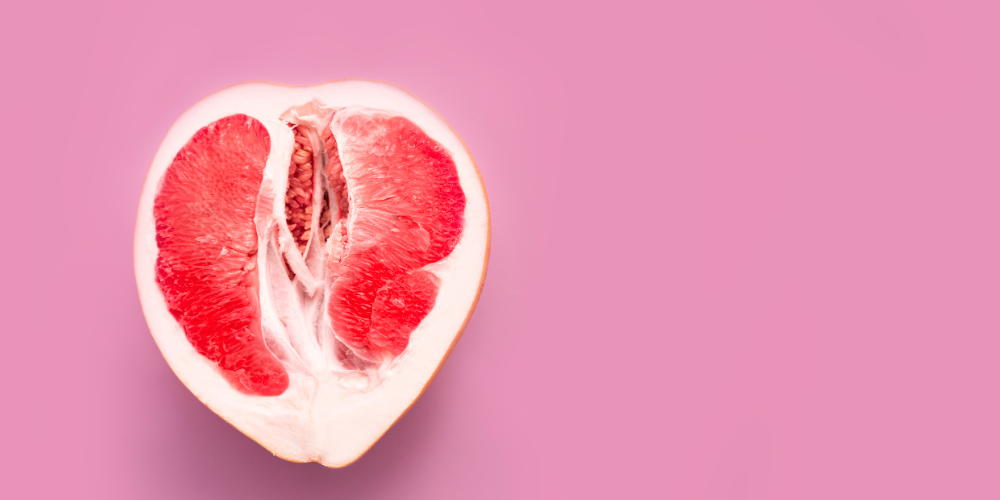 The image is of a pink heart-shaped fruit with a bite taken out of it, resembling a citrus fruit like an orange or grapefruit. The tags associated with the image are fruit, citrus, natural foods, superfood, produce, orange, grapefruit, and food.