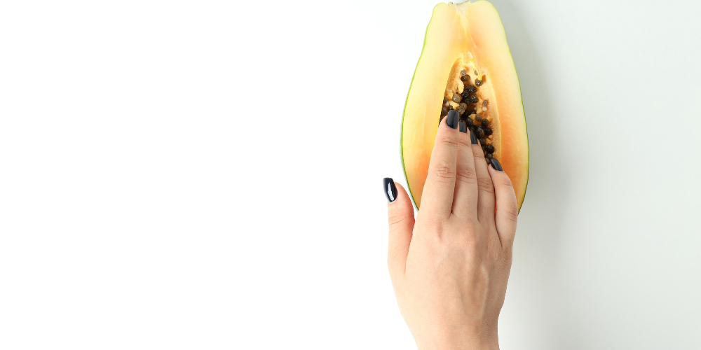 The image is of a person holding a papaya.