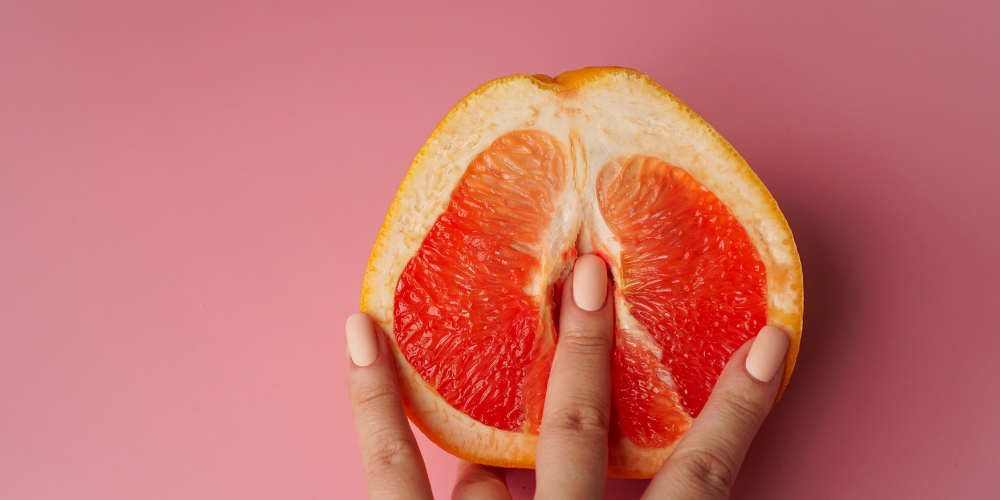 The image is of a hand holding a slice of orange.