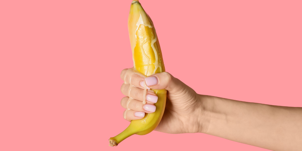 The image shows a person holding a banana in their hand.