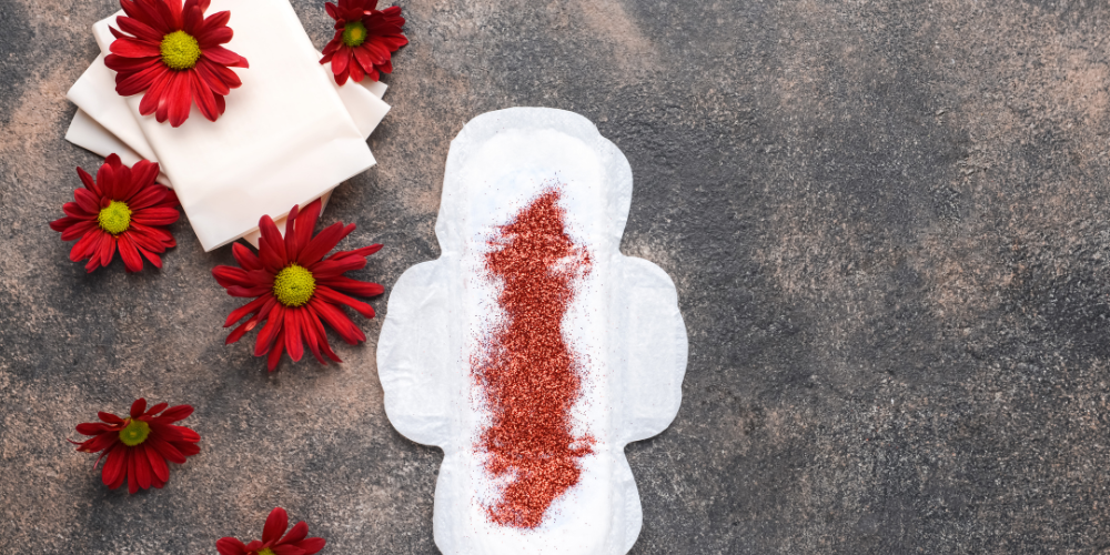 The image depicts a pair of red and white socks with a floral design. The socks are placed on the ground outdoors. Tags: carmine, flower, red.