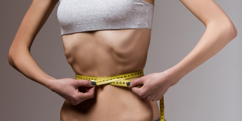 The image shows a person measuring their waist. The content provided seems to be random numbers and may not be relevant to the description of the image. Tags associated with the image include stomach, person, clothing, waist, and belly.