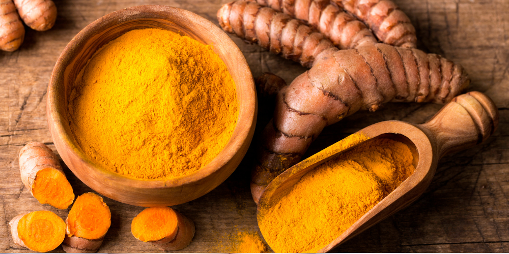 The image is of a bowl of food containing turmeric as a spice, and it is taken indoors.