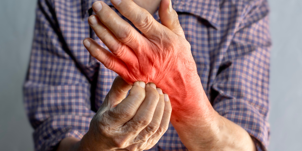 The image shows a man holding his hands together.