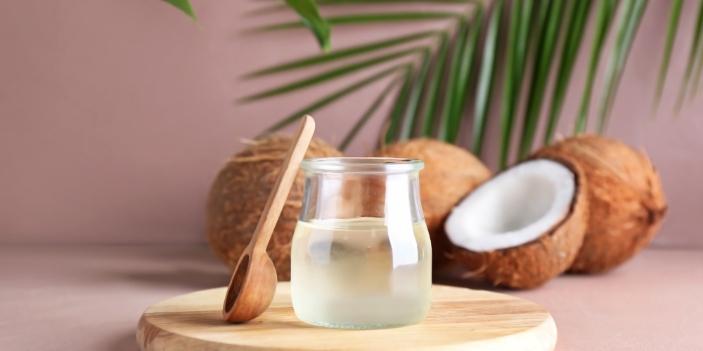 The image features a group of objects on a table, including coconuts and plants, indoors. 