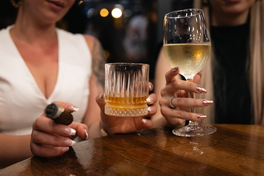 a couple of women sitting at a table holding wine glasses