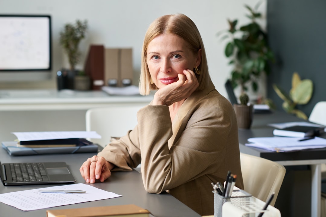 A businesswoman poses at her desk.