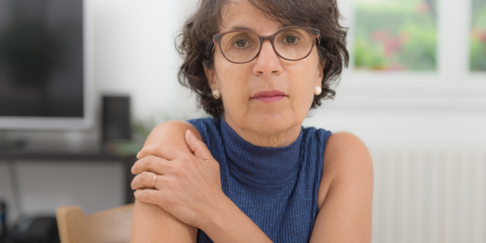 a woman with glasses and a blue top