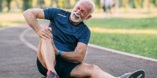 The image shows a man holding his leg in pain