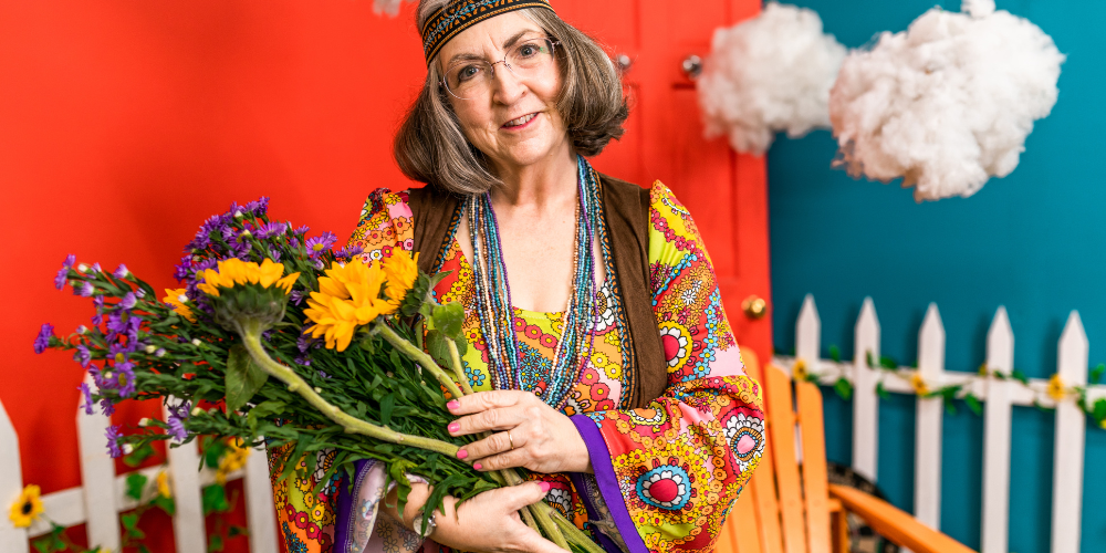 an old woman smiling and holding a bouquet