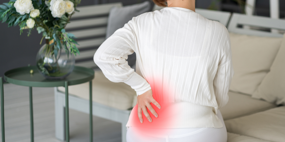 a woman holding her lower back in pain