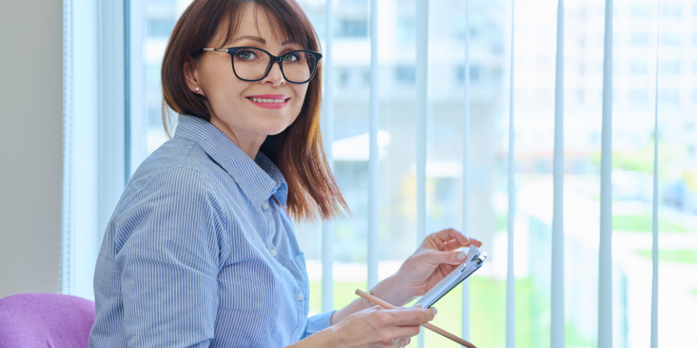 a woman holding a pen and notebook