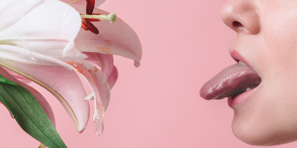 a person's tongue out and a flower