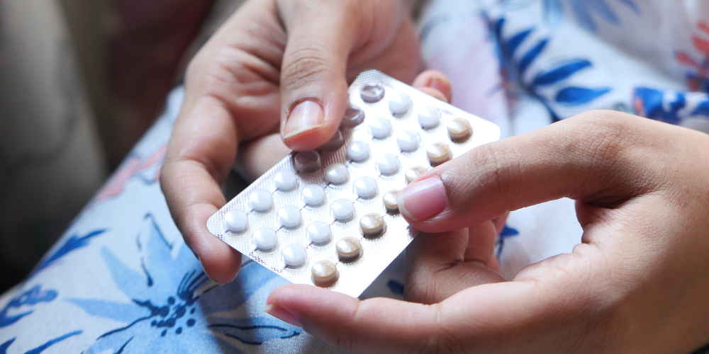 a person holding a pack of pills