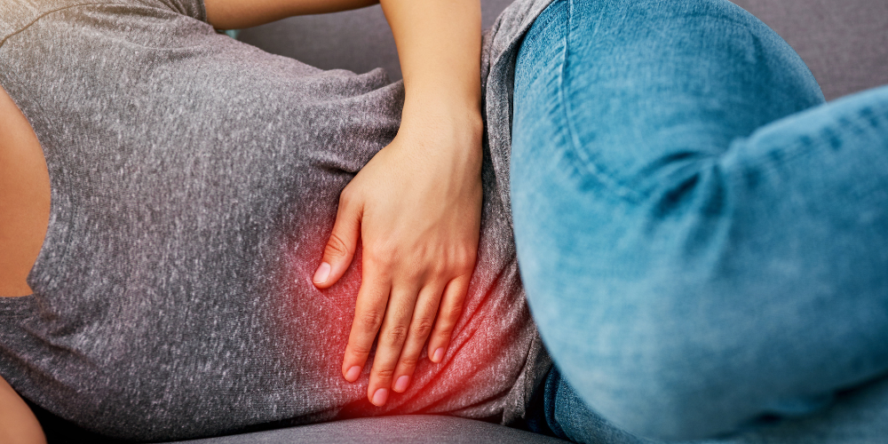 a woman laying down sideway while holding her stomach