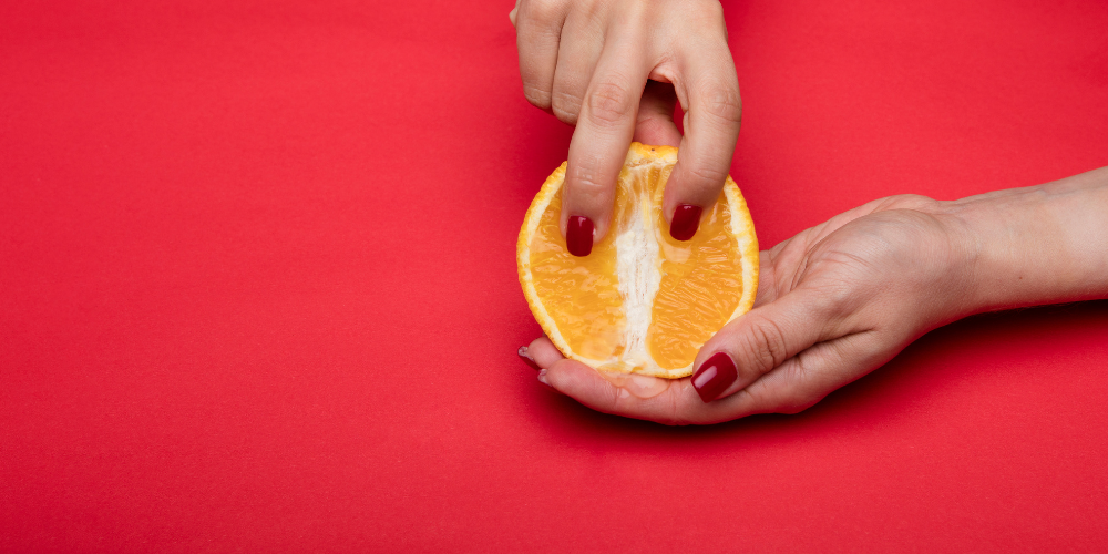 The image shows a person holding an orange.