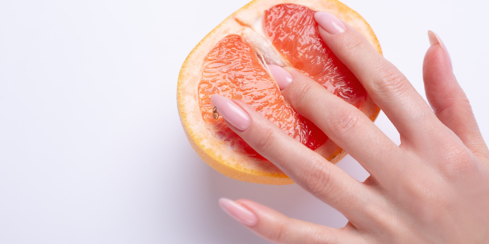 The image shows a person's hand holding a fruit.