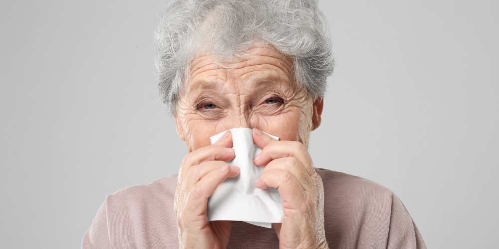 The image shows a woman sneezing.