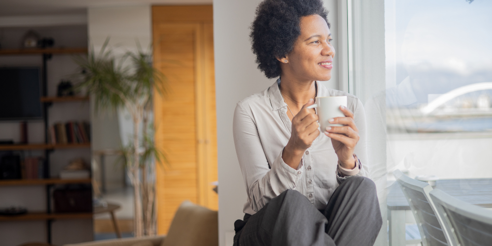 a woman having a cup of coffee indoors