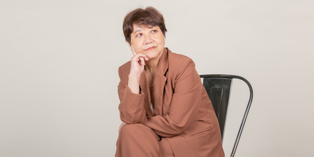 a woman sitting on a chair with a white background