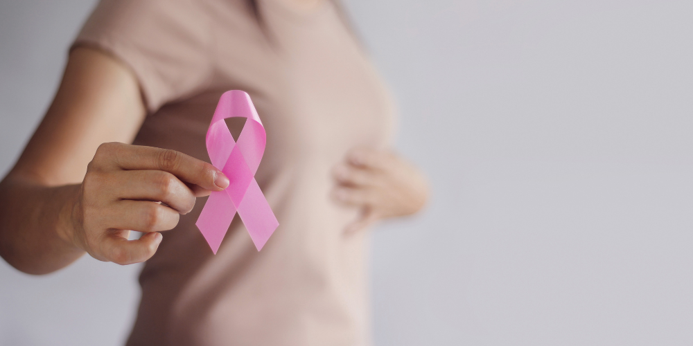 a woman holding a pink ribbon