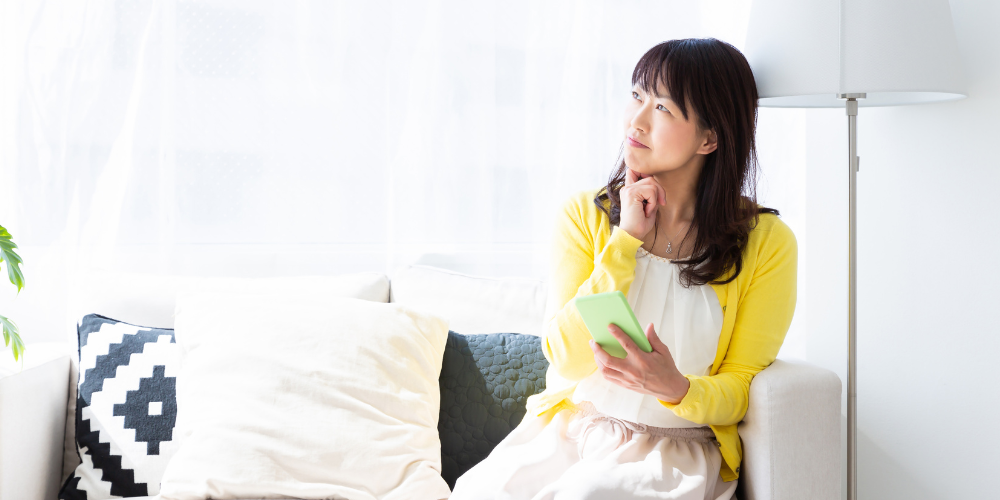 a woman in a yellow top sitting indoors