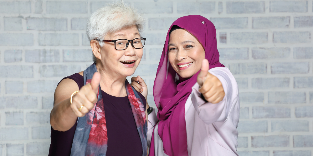 two women taking a picture with their thumbs up