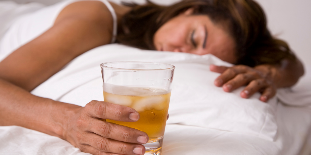 a woman asleep with a beer next to her