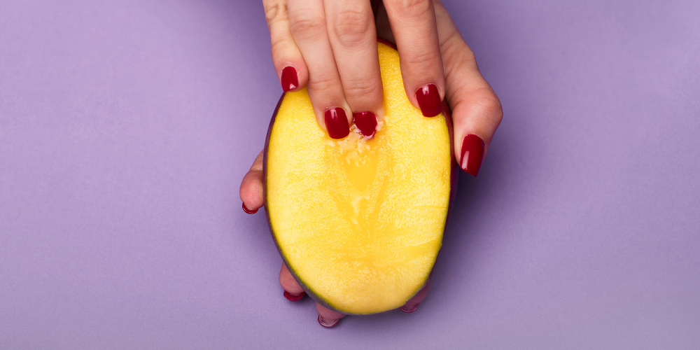 The image shows a person holding a sliced fruit.