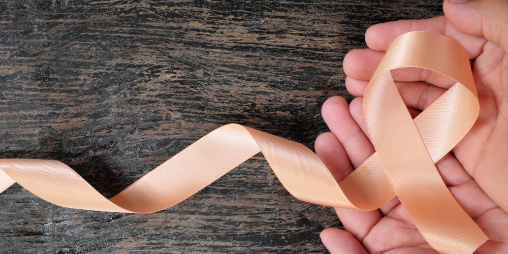 a person holding a pink ribbon