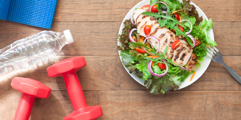 salad, dumbbell and bottled water displayed